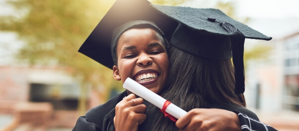 Graduates holding their diploma hugging