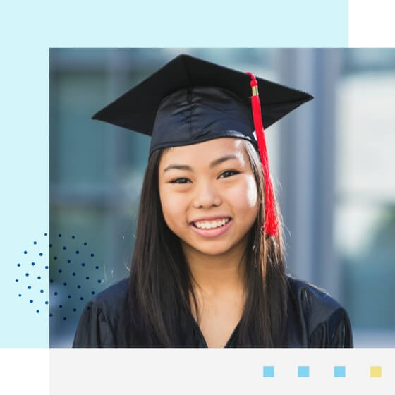 Graduated student wearing a graduation hat and smiling to the camera